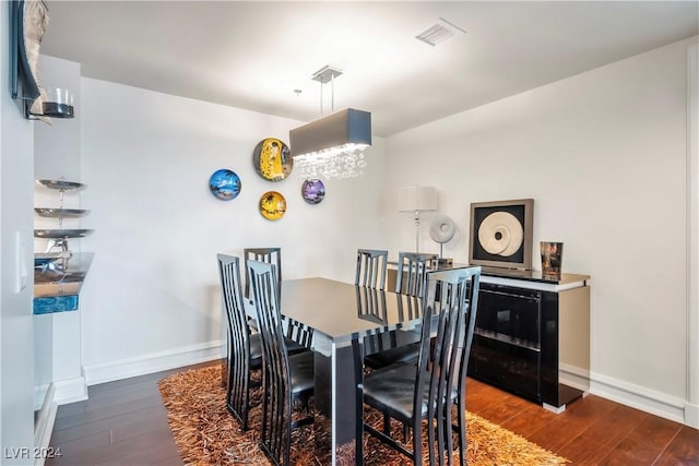 dining area with baseboards, visible vents, and wood finished floors