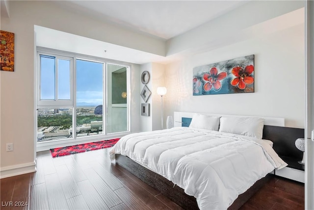 bedroom with baseboards and dark wood-type flooring