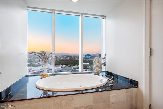 bathroom featuring tiled tub and a wealth of natural light