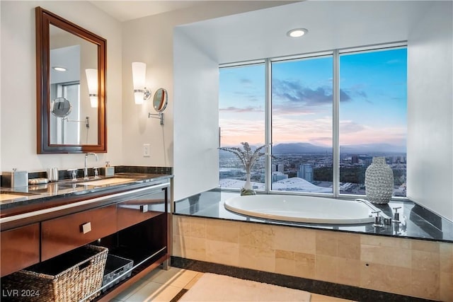 full bath featuring vanity, tile patterned flooring, tiled tub, and a wealth of natural light