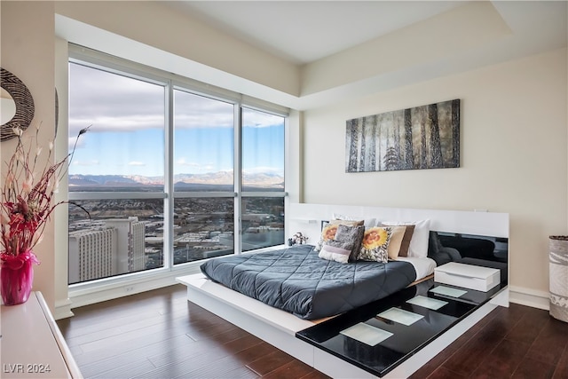 bedroom featuring a mountain view and dark wood-type flooring