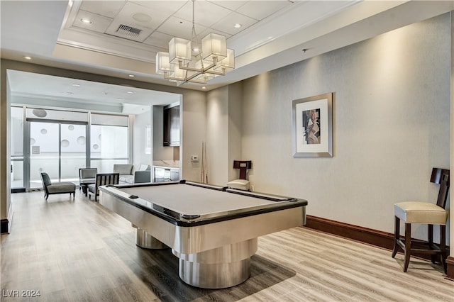 recreation room with a tray ceiling, crown molding, hardwood / wood-style flooring, and billiards