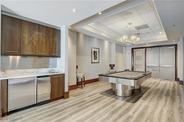 rec room with pool table, sink, light wood-type flooring, and a raised ceiling