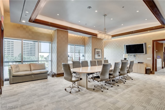 carpeted dining room with a tray ceiling