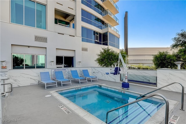 view of swimming pool with a patio and a community hot tub