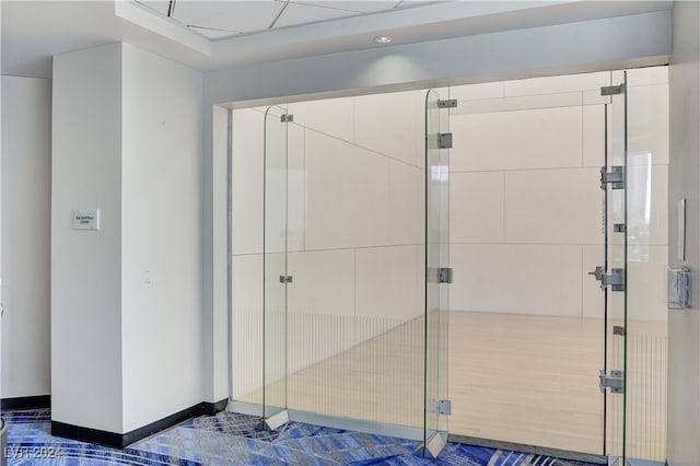 bathroom with a paneled ceiling and walk in shower