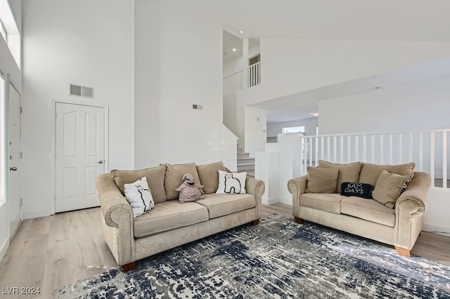 living room with hardwood / wood-style floors and high vaulted ceiling