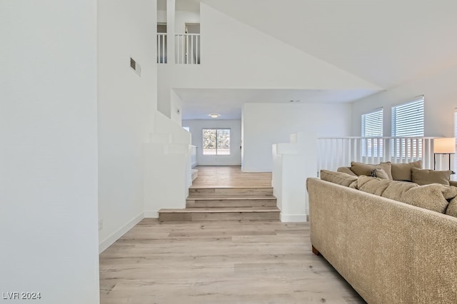 stairs featuring a towering ceiling and hardwood / wood-style floors