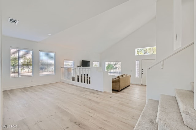 unfurnished living room featuring light hardwood / wood-style flooring and high vaulted ceiling