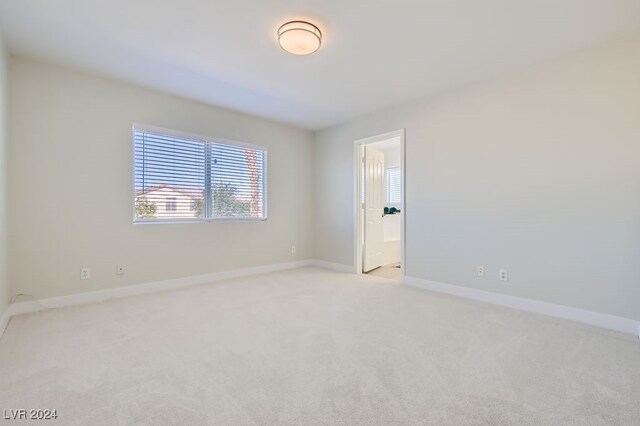 unfurnished room featuring light carpet