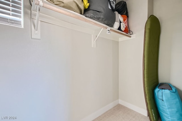 walk in closet featuring light carpet