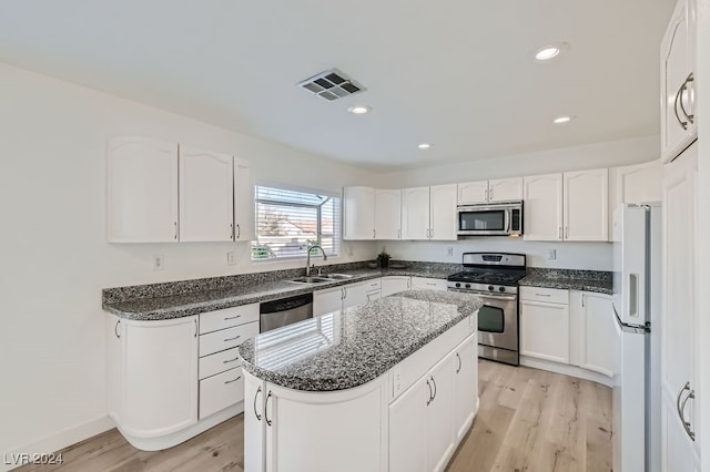 kitchen featuring a kitchen island, stainless steel appliances, sink, white cabinets, and light hardwood / wood-style floors