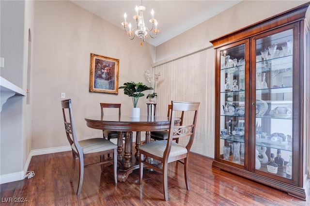 dining space with hardwood / wood-style floors and an inviting chandelier