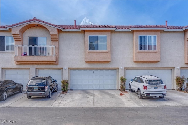 townhome / multi-family property with a garage and a balcony