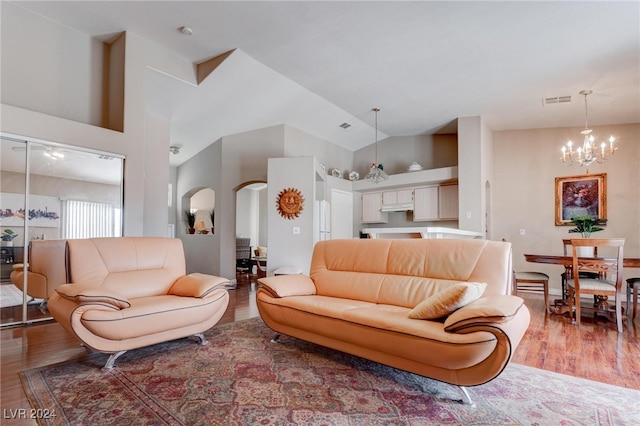 living room featuring a chandelier, hardwood / wood-style flooring, and high vaulted ceiling