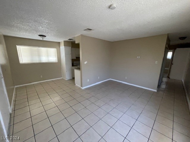 tiled spare room with a textured ceiling