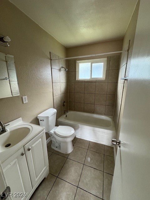 full bathroom with toilet, tile patterned flooring, tiled shower / bath combo, vanity, and a textured ceiling