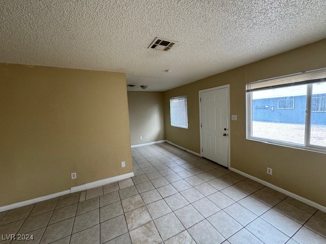 entryway featuring a textured ceiling and light tile patterned flooring