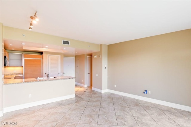 interior space with light tile patterned floors and sink