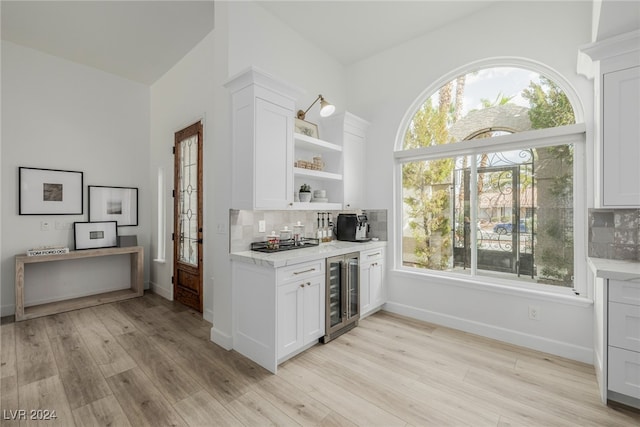 kitchen featuring light hardwood / wood-style floors, white cabinets, and beverage cooler