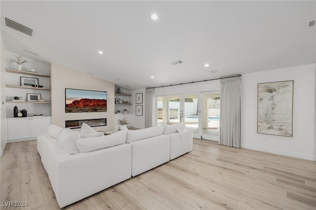 living room with light hardwood / wood-style flooring and vaulted ceiling