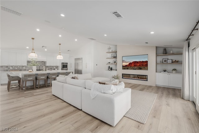 living room featuring lofted ceiling and light wood-type flooring