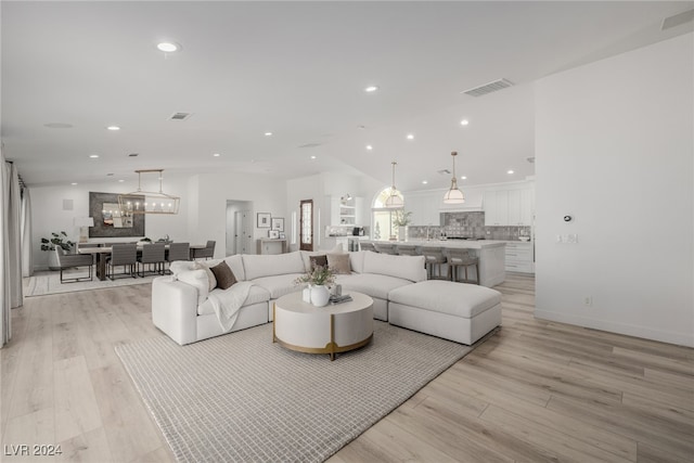 living room with a chandelier and light wood-type flooring