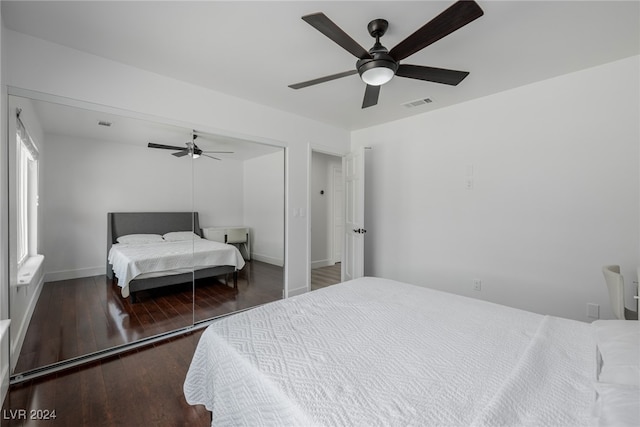 bedroom with a closet, ceiling fan, and dark hardwood / wood-style floors