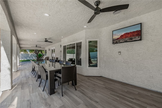 dining area with a textured ceiling, wood-type flooring, and a healthy amount of sunlight