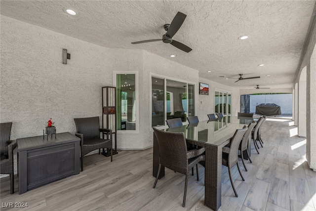 dining room with ceiling fan, a textured ceiling, and light wood-type flooring