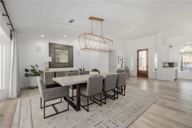 dining space with vaulted ceiling and light hardwood / wood-style floors