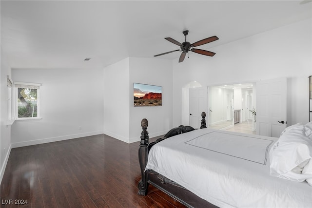 bedroom with ceiling fan, dark wood-type flooring, and vaulted ceiling