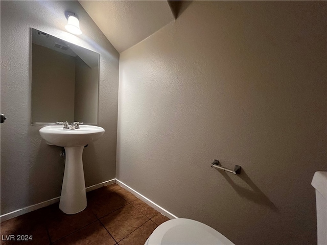 bathroom featuring toilet, tile patterned floors, and lofted ceiling