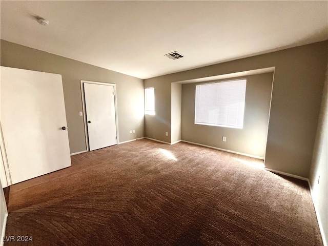 carpeted spare room with lofted ceiling