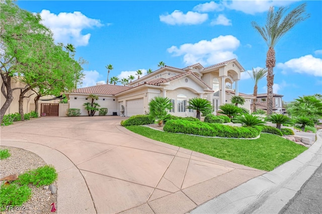 mediterranean / spanish-style home featuring a garage and a front lawn