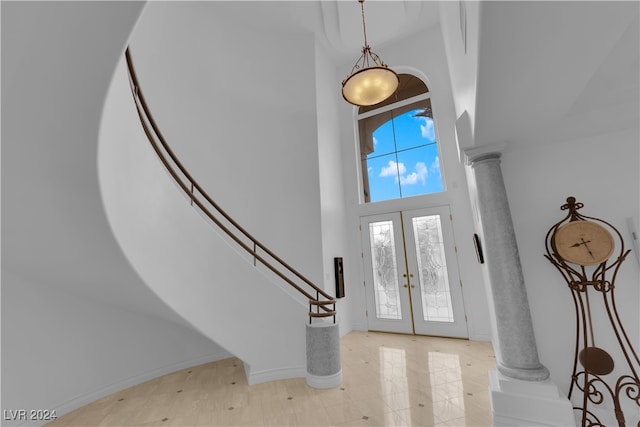 foyer featuring a high ceiling, french doors, and decorative columns