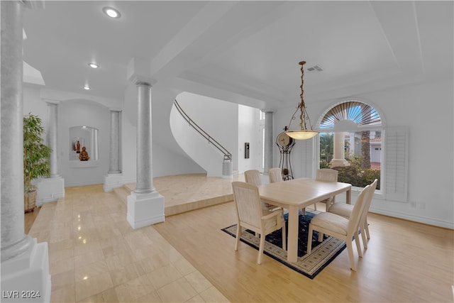 dining space featuring ornate columns and light wood-type flooring