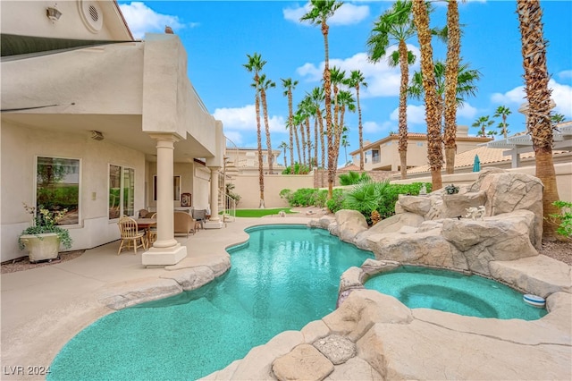 view of swimming pool featuring a patio and an in ground hot tub