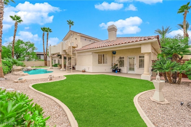 back of property featuring a patio area, a fenced in pool, and a lawn