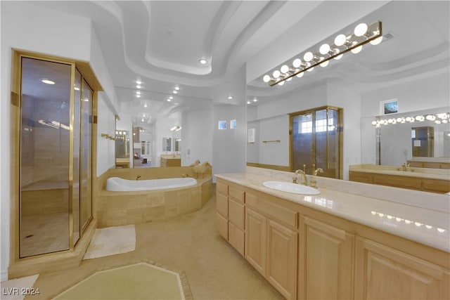 bathroom with vanity, plus walk in shower, and a raised ceiling