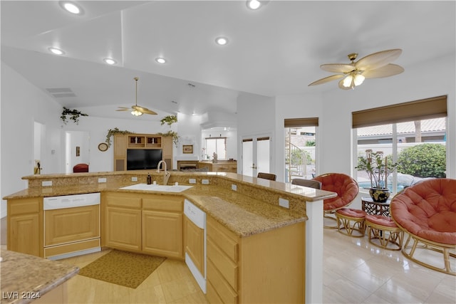 kitchen featuring light brown cabinetry, sink, white dishwasher, lofted ceiling, and light stone counters