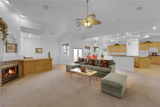 living room featuring ceiling fan, high vaulted ceiling, and light carpet