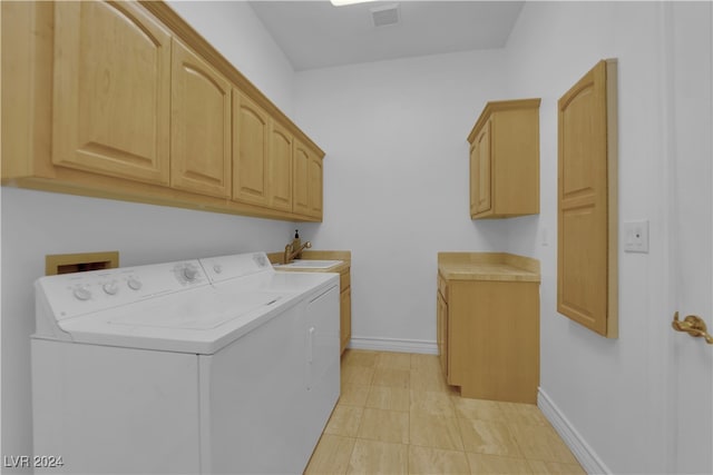 clothes washing area featuring sink, independent washer and dryer, cabinets, and light tile patterned floors