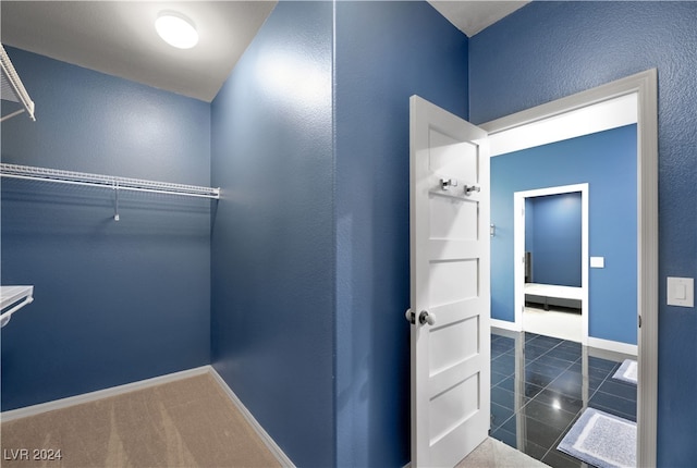 walk in closet featuring dark tile patterned flooring