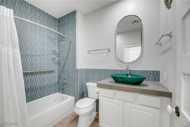 full bathroom featuring toilet, tile patterned floors, tile walls, vanity, and shower / bathtub combination with curtain