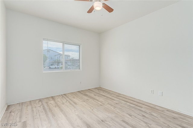 empty room with ceiling fan and light hardwood / wood-style flooring