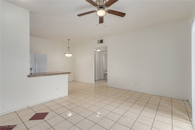 tiled empty room featuring ceiling fan