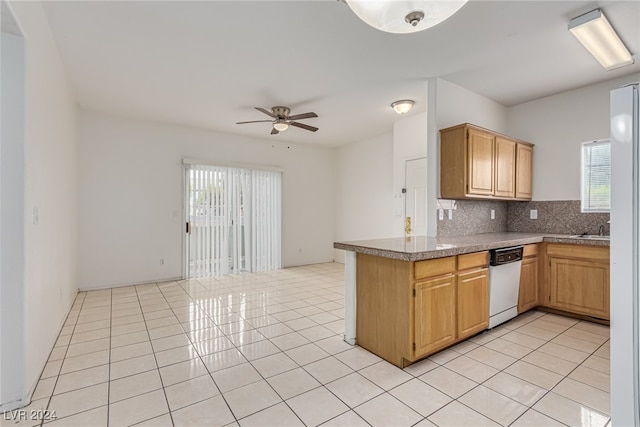 kitchen featuring decorative backsplash, a healthy amount of sunlight, light tile patterned flooring, and white dishwasher