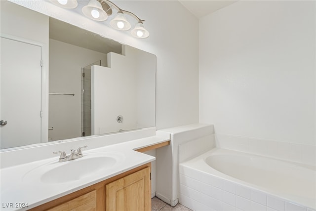 bathroom with vanity, tile patterned flooring, and tiled tub