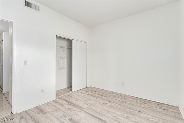 unfurnished bedroom featuring a closet and light wood-type flooring